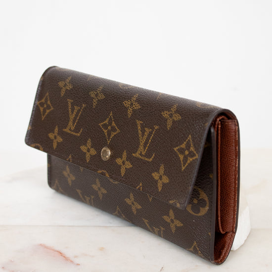 Louis Vuitton wallet with monogram pattern on a marble surface