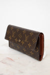 Louis Vuitton wallet with monogram pattern on a marble surface
