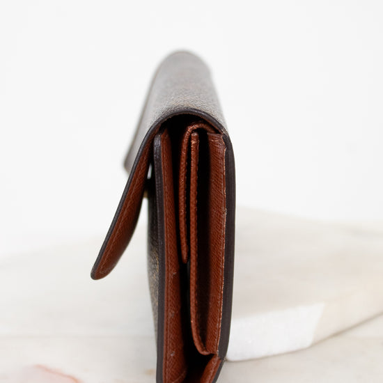Close-up of side profile of a leather wallet on a white marble surface