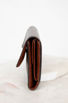 Close-up of side profile of a leather wallet on a white marble surface