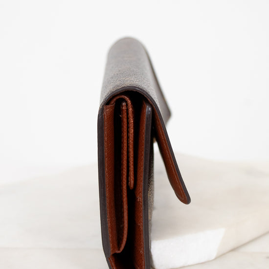 Side view of wallet with brown interior on a white marble surface