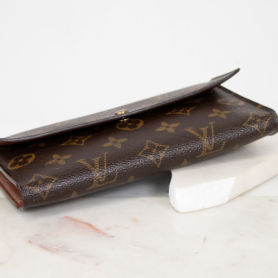 Brown Louis Vuitton wallet on a marble surface