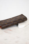 Brown wallet with monogram pattern on a marble surface
