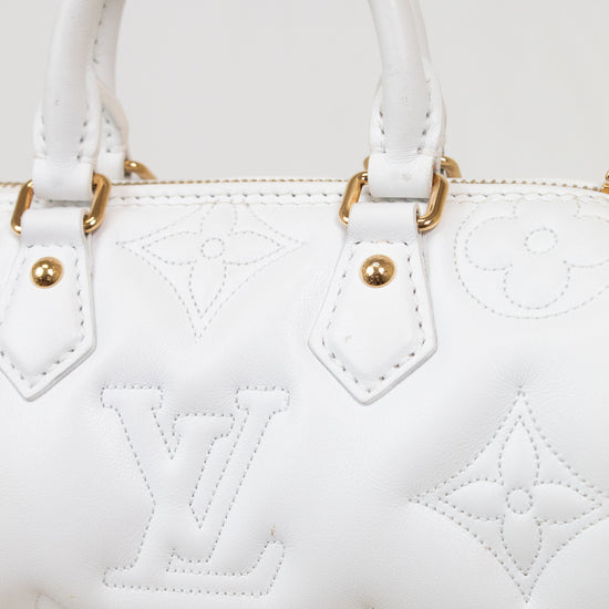 White leather handbag with embossed Louis Vuitton monogram pattern and gold-tone hardware, shown in a close-up studio-style shot.