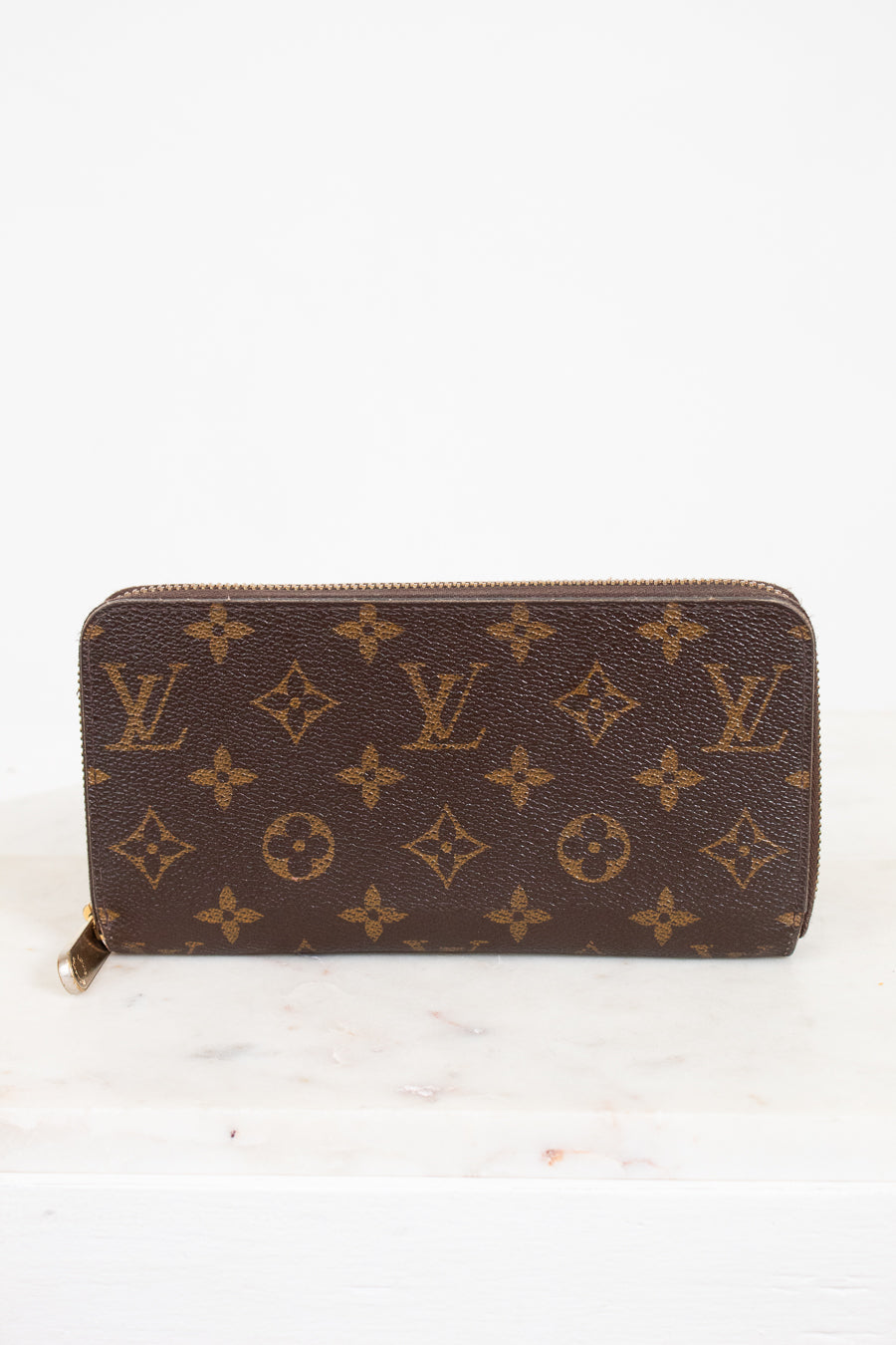 Brown wallet with monogram pattern on a white background