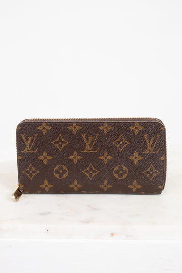 Brown wallet with monogram pattern on a white background
