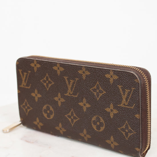 Louis Vuitton wallet with monogram pattern on a white background