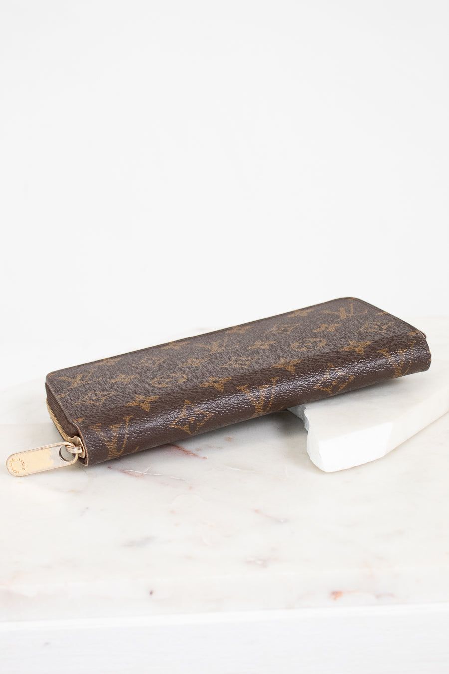 Brown patterned wallet on a white surface