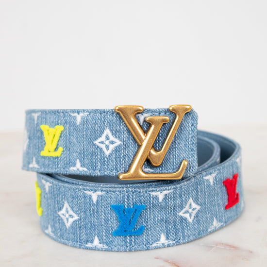 Louis Vuitton denim belt with gold buckle and mixed color monogram on white background