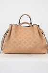 Beige handbag with monogram pattern on a white background