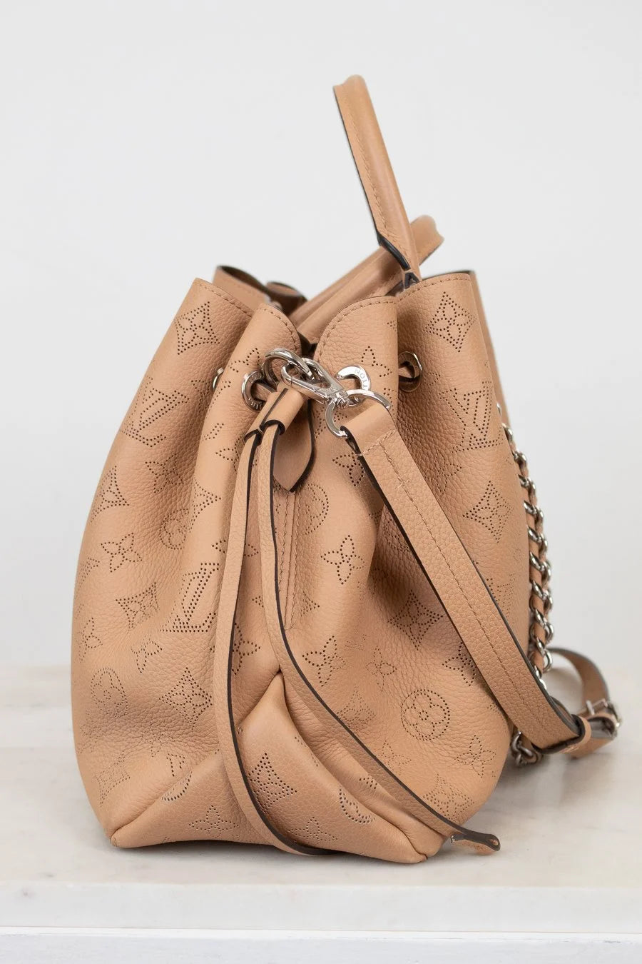 Beige handbag with chain detail on a white background