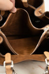 Close-up of a brown leather handbag with visible stitching