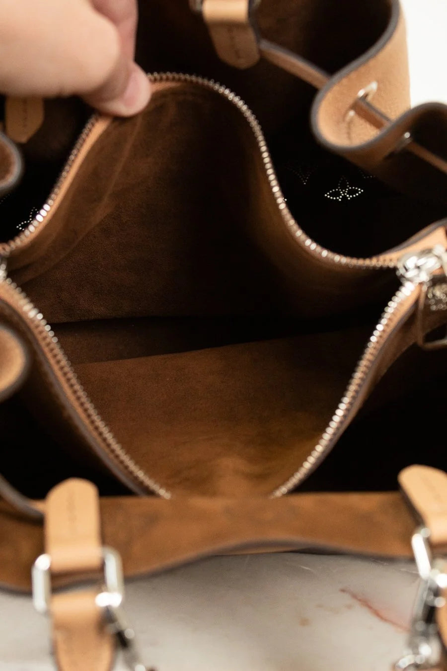 Close-up of a brown leather handbag with visible stitching