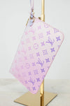 Ombre Pink pouch with purple monogram pattern on a gold stand against a white background