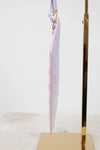 Pink piping pastel-colored bag on a gold stand against a white background