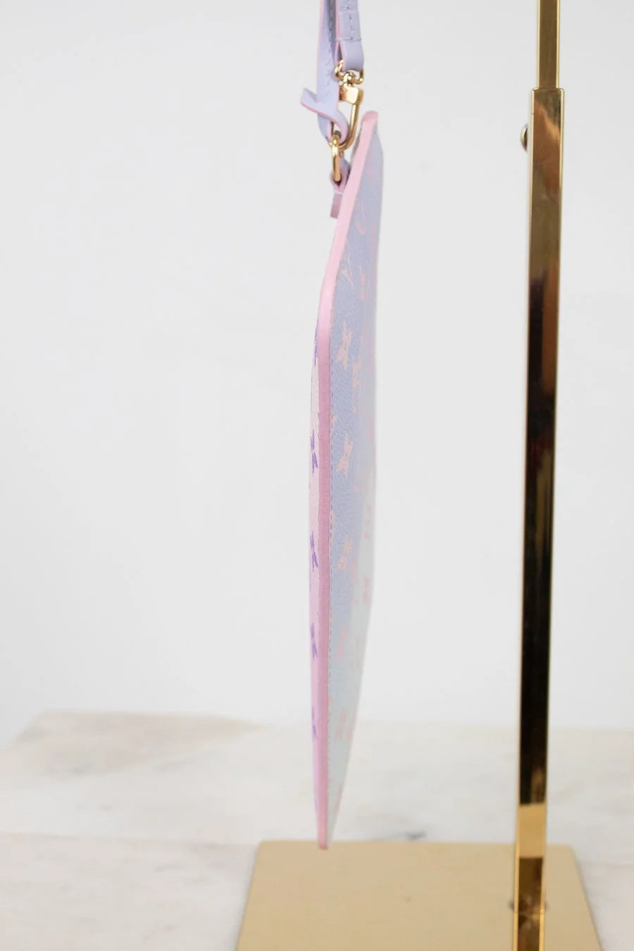 Pink piping pastel-colored bag on a gold stand against a white background