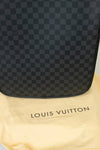 Black checkered Louis Vuitton bag on a beige Louis Vuitton dust bag