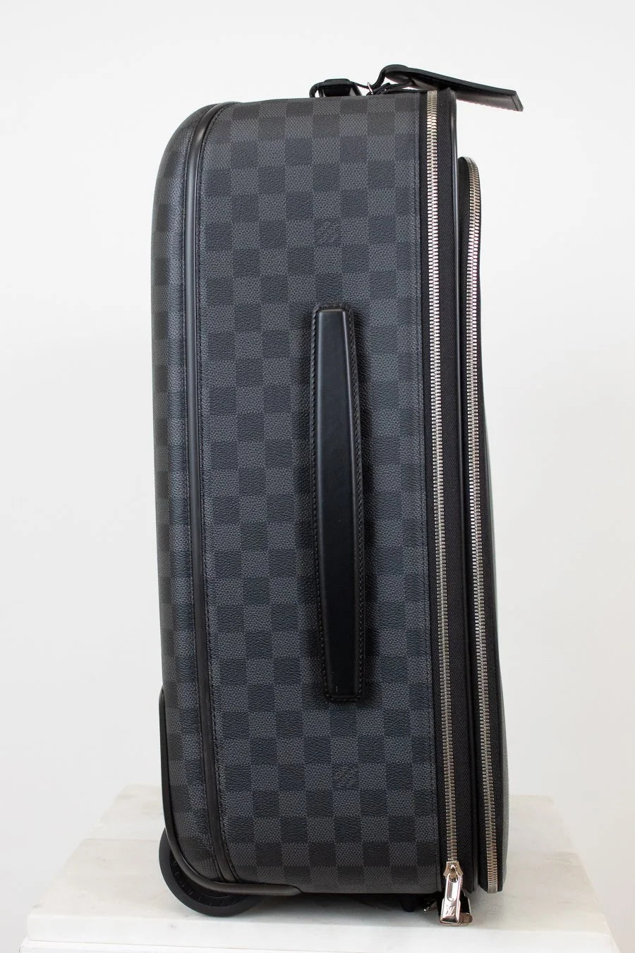 Black checkered patterned suitcase with a handle on a white background