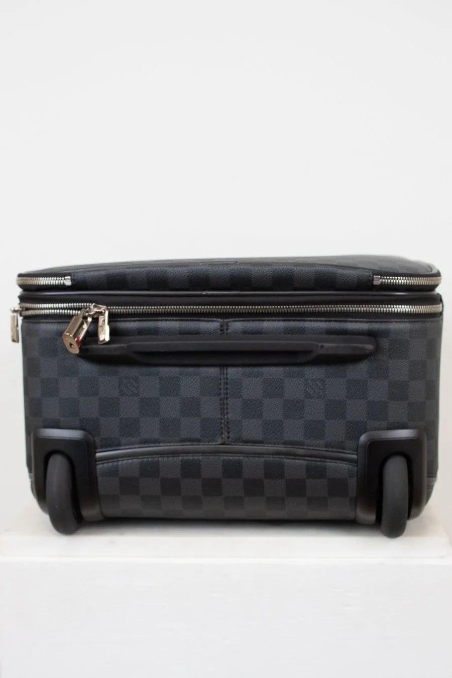 Black checkered suitcase with wheels on a white background