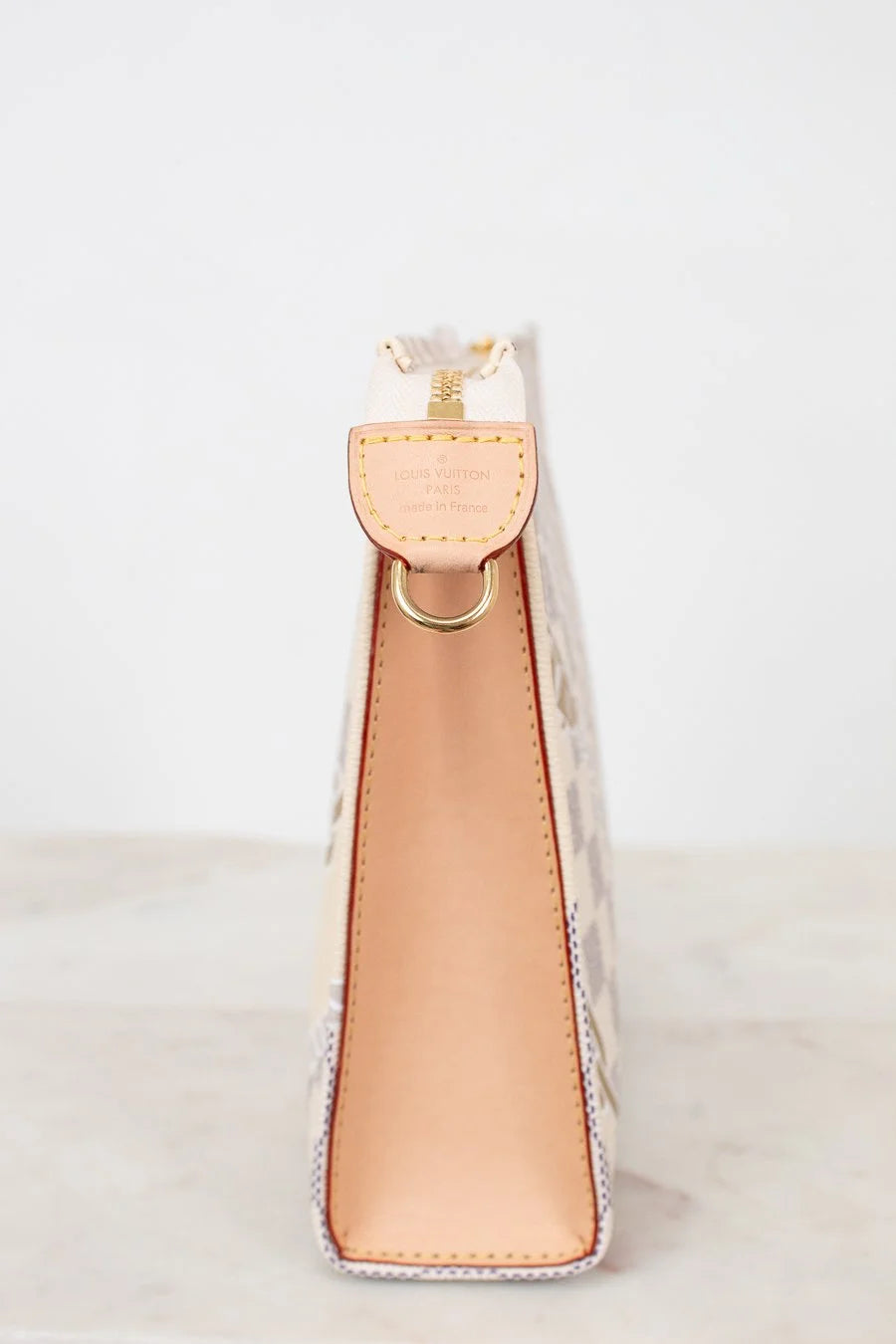 tan leather side profile of clutch/pouch on a white background