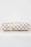 Bottom of checkered patterned pouch on a white surface