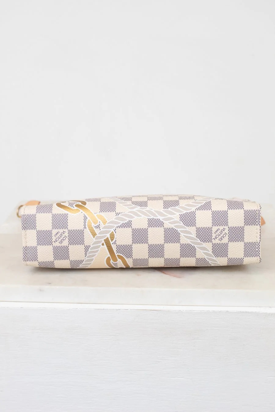 Bottom of checkered patterned pouch on a white surface