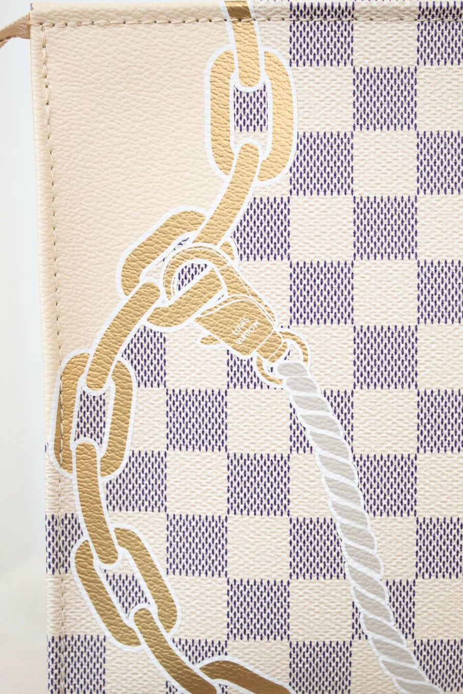 Close-up of a damier azur with chain motif detail with a checkered pattern and chain design.