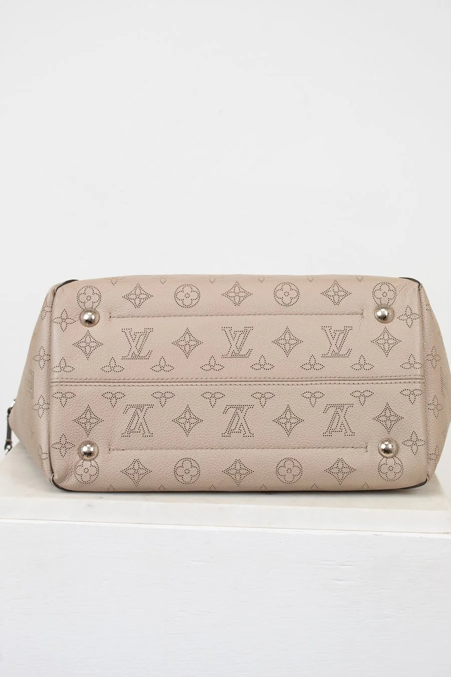 Beige handbag with monogram pattern on a white background