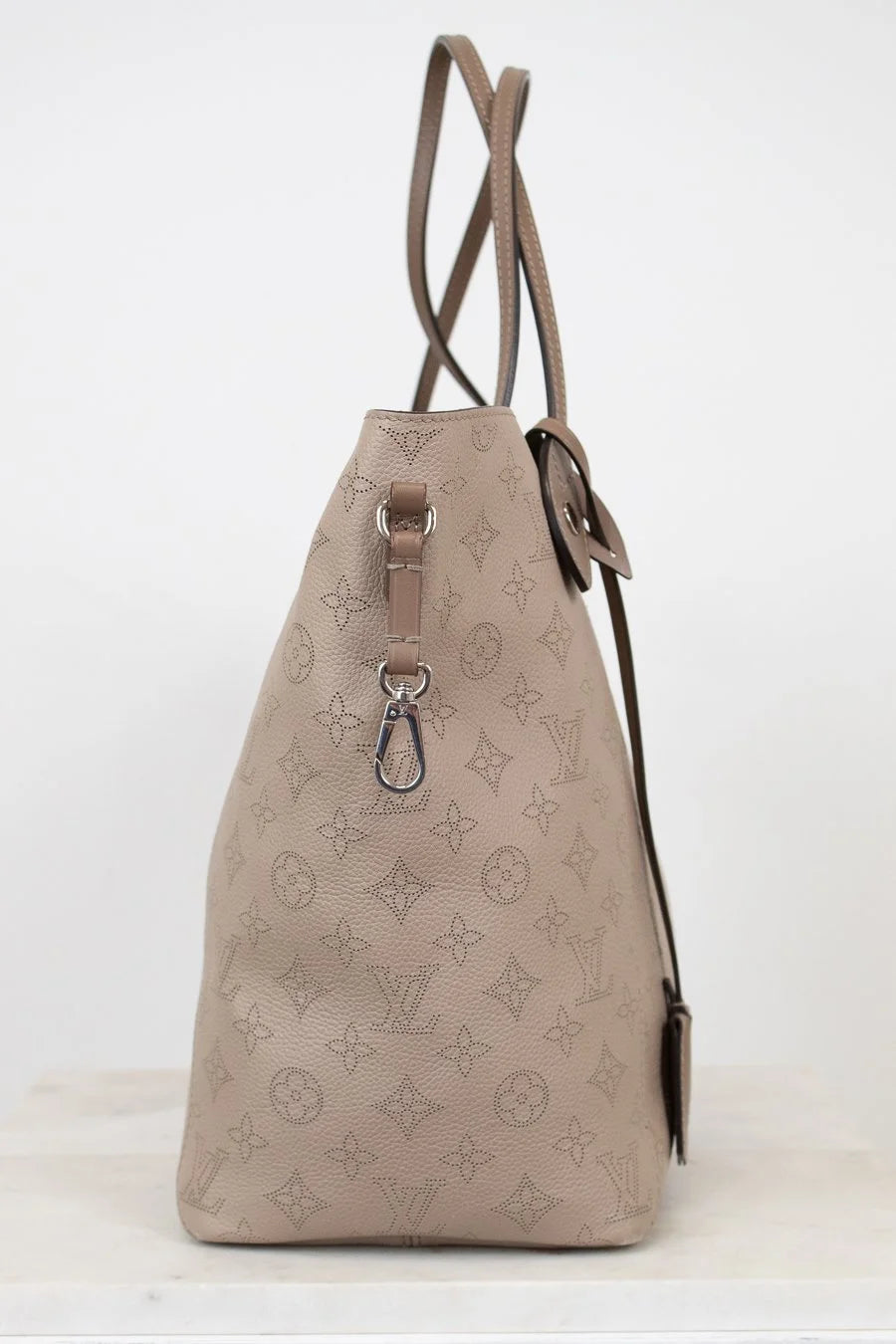 Beige handbag with monogram pattern on a white background