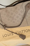 Louis Vuitton handbag with monogram pattern on a white background