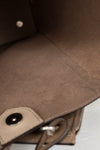 Close-up of  beige leather interior of bag with a visible brand logo.