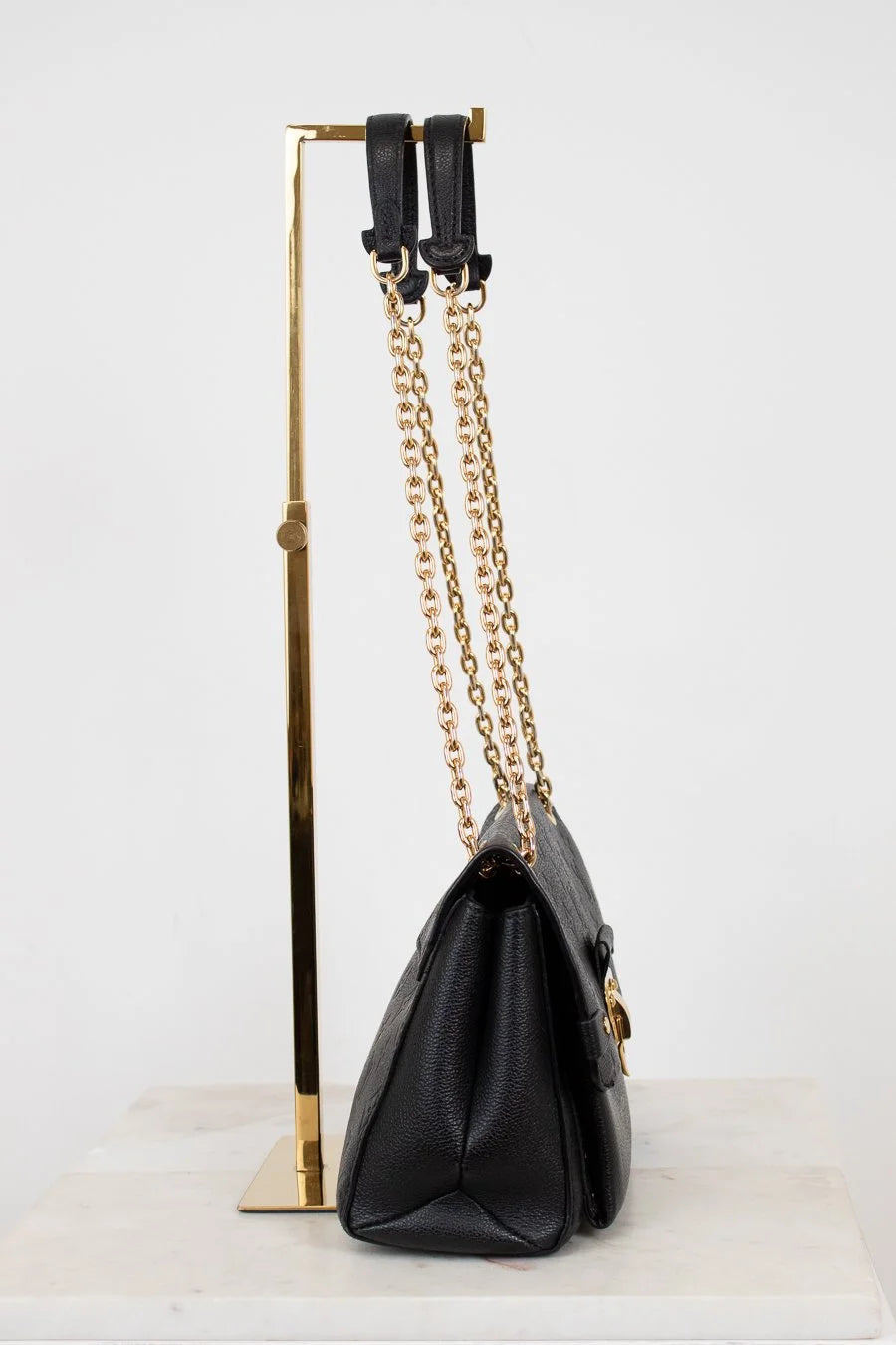 Black handbag with gold chain on a white background