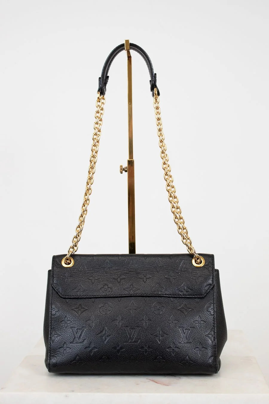 Black handbag with gold chain strap on a white background