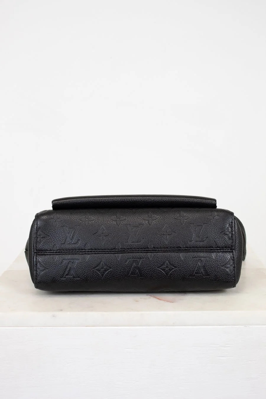 Black handbag with a pattern on a white background