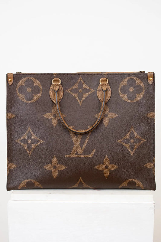 Brown handbag with gold monogram pattern on a white background