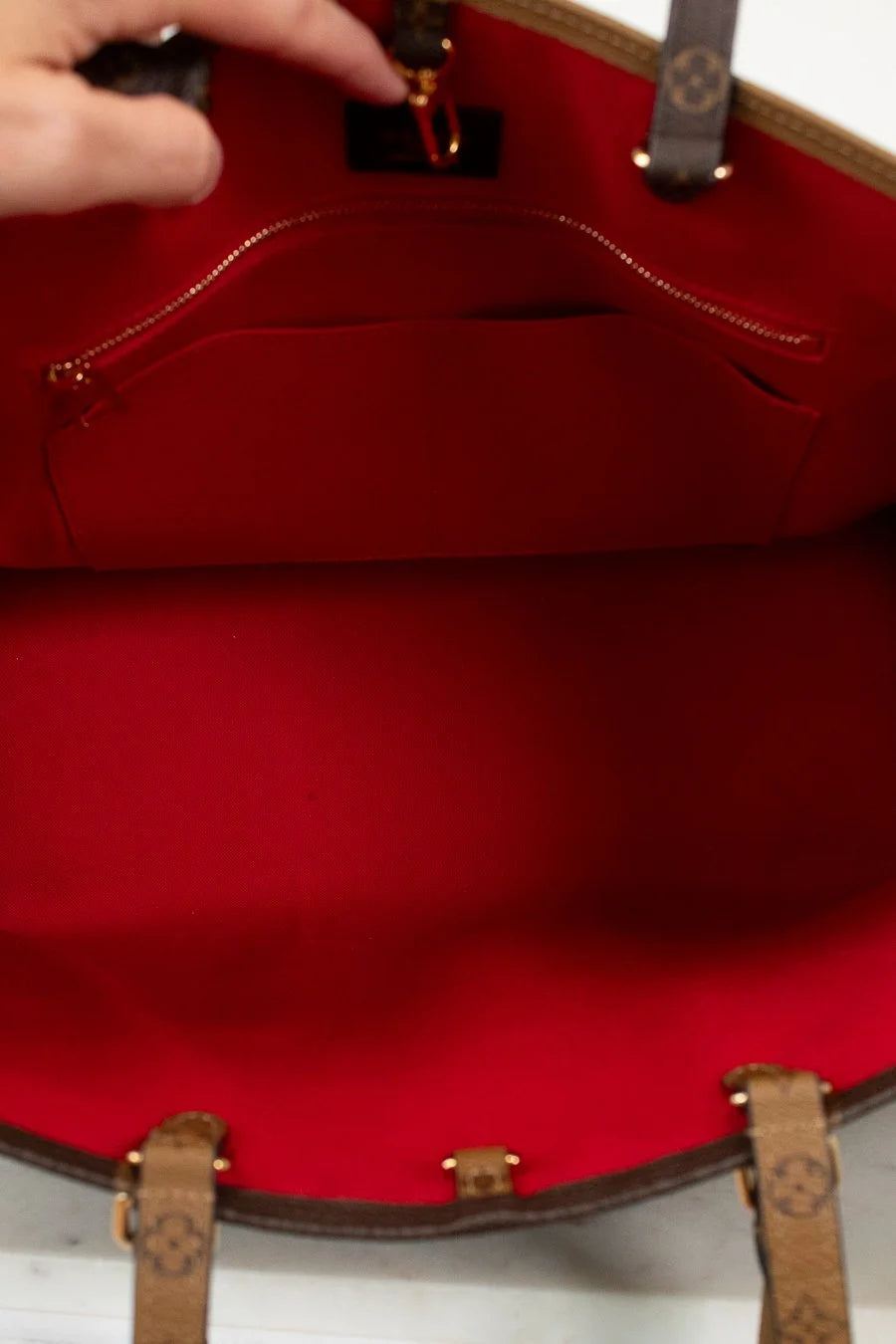 Close-up of a interior red suede with a hand adjusting the strap.