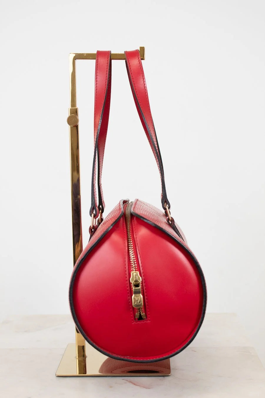 Red handbag with gold zipper accents on a white background