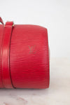 Red handbag with visible brand logo on a light background