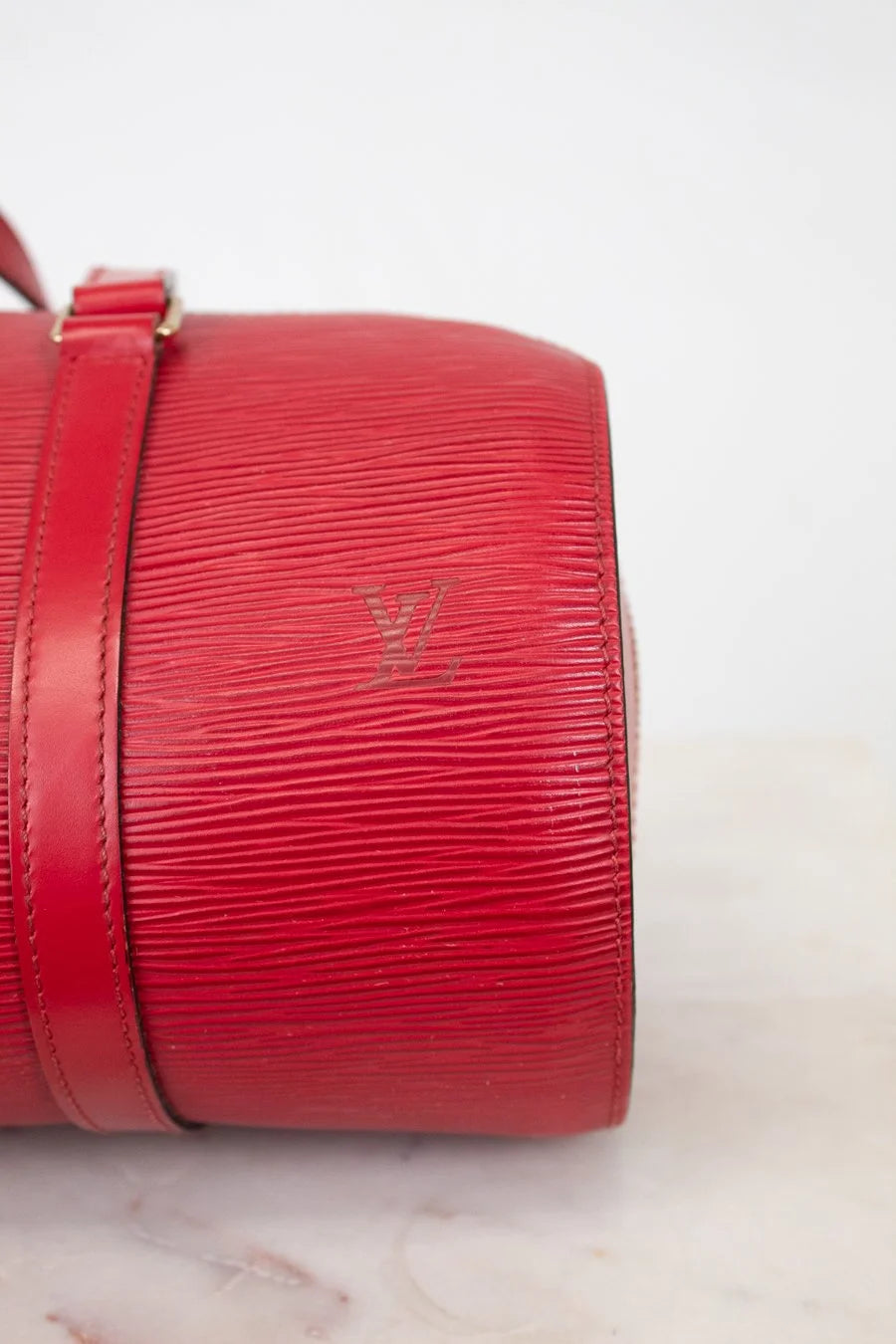 Red handbag with visible brand logo on a light background