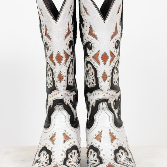 A pair of white western cowboy boots with black and brown leather details, shown from the front against a plain white background.