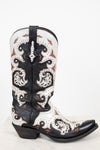 A single western cowboy boot with a black and white leather base, featuring intricate orange-brown accents, and silver studded detail, set against a plain white background.