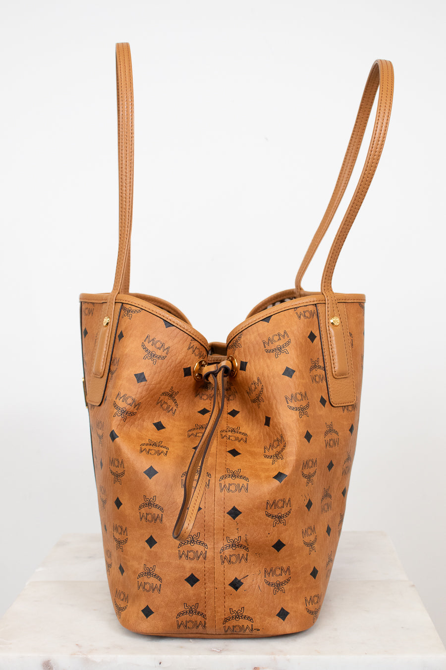 Tan leather handbag with visible brand logo on a white background