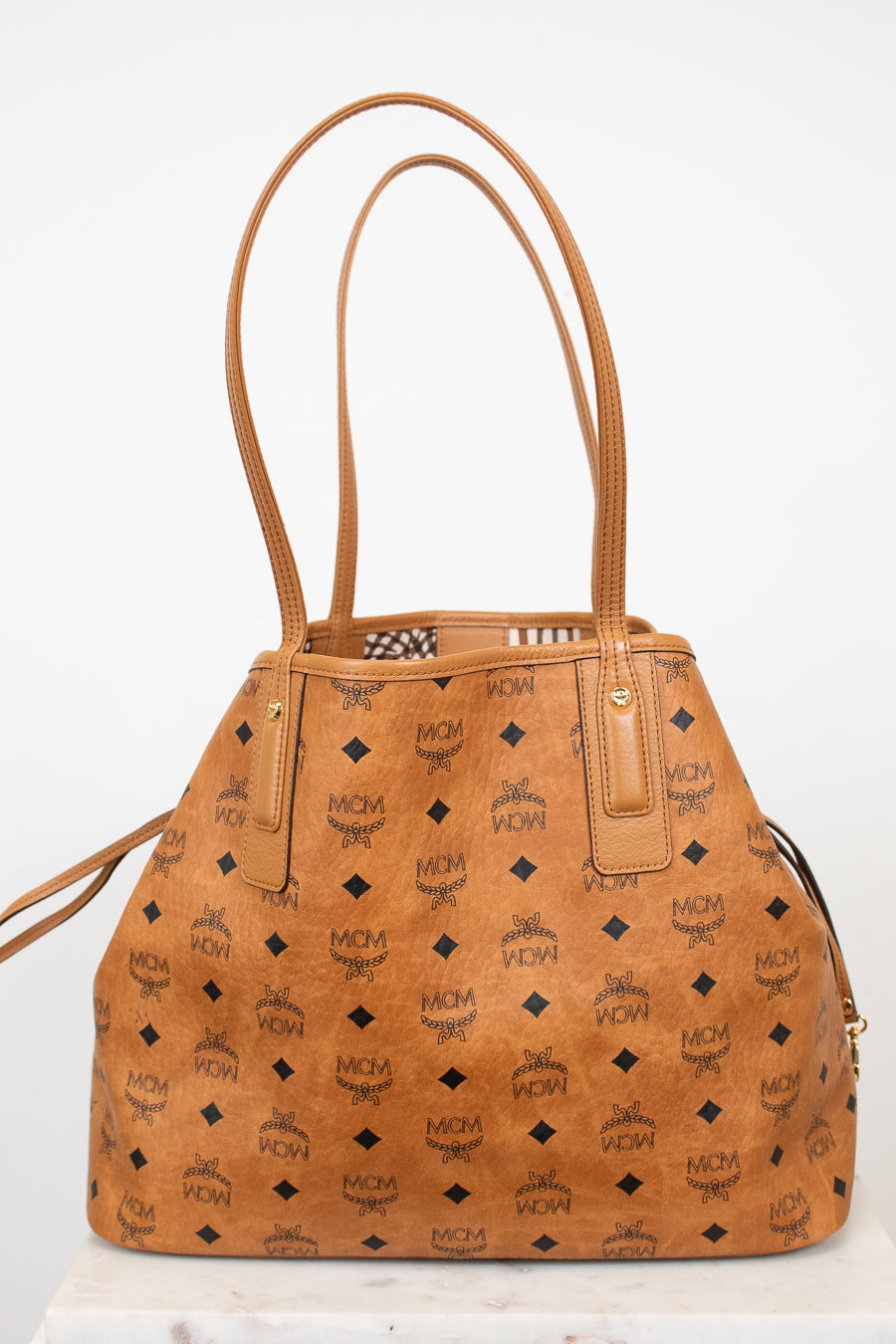 Brown handbag with a visible brand logo on a white background