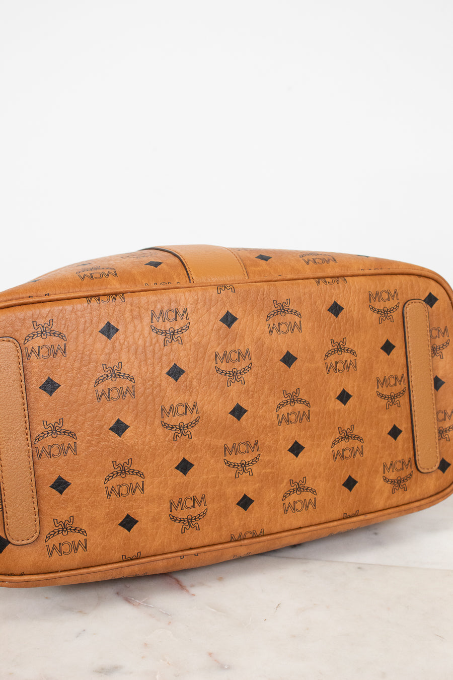 Brown leather bag with black pattern on a white background