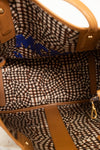 Close-up of a patterned handbag with visible brand name.