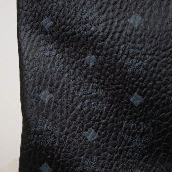 Close-up of a black textured pouch with a red border on a white background