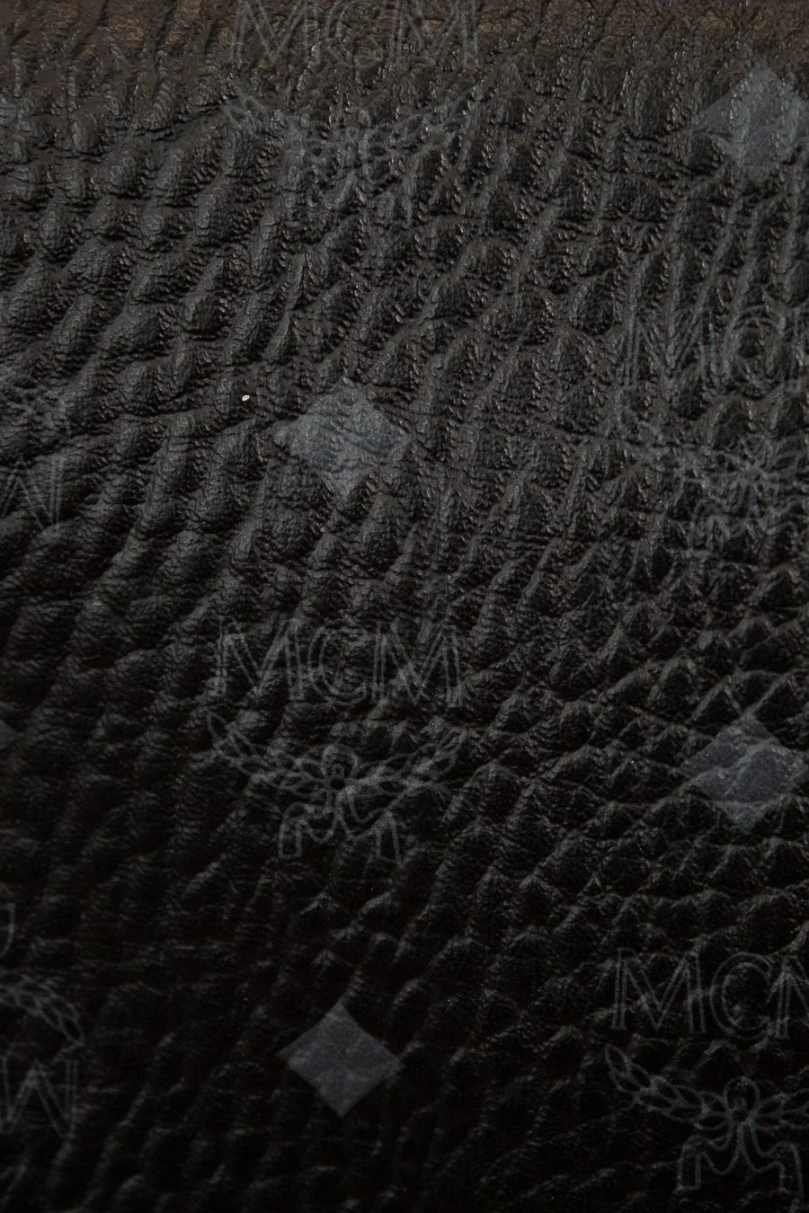 Close-up of a textured black fabric with brand logo
