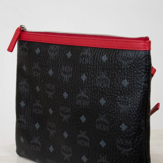 Black textured pouch with red zipper on a white background