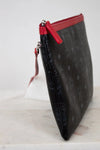Black textured clutch bag with a red zipper on a white background