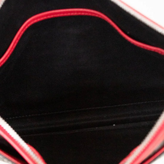 Close-up of a purse's black interior with red stitching held by a hand.